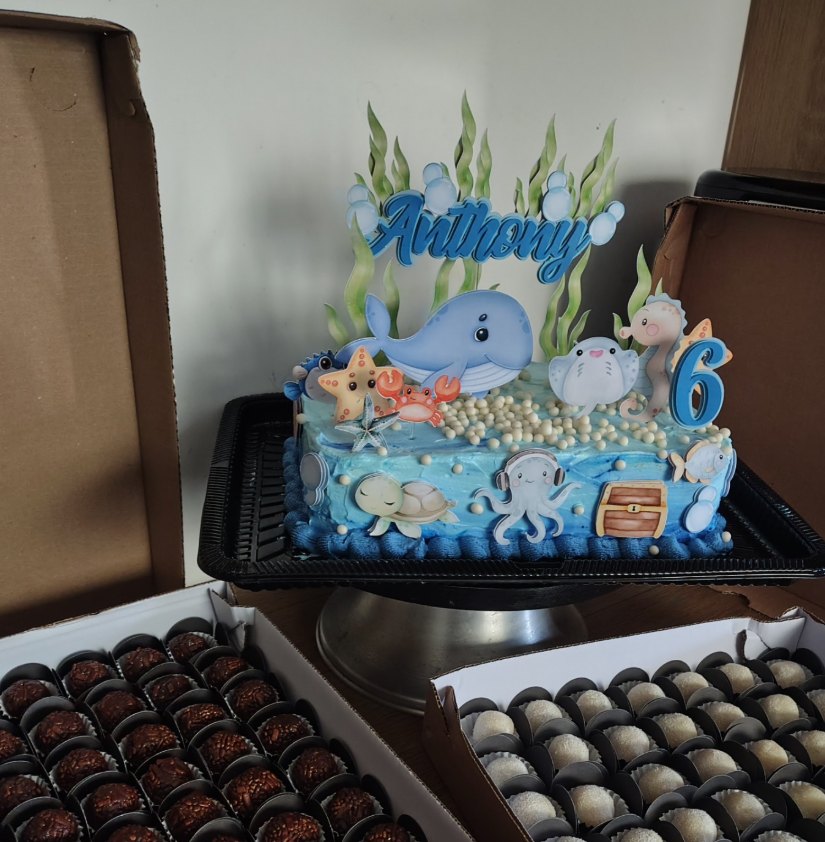 Bolo azul com tema fundo do mar e caixas de brigadeiros